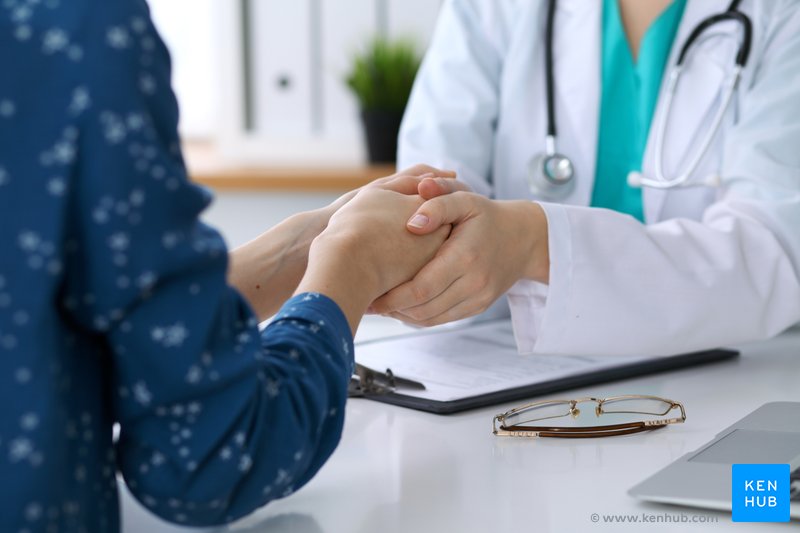 Doctor holds hands with patient